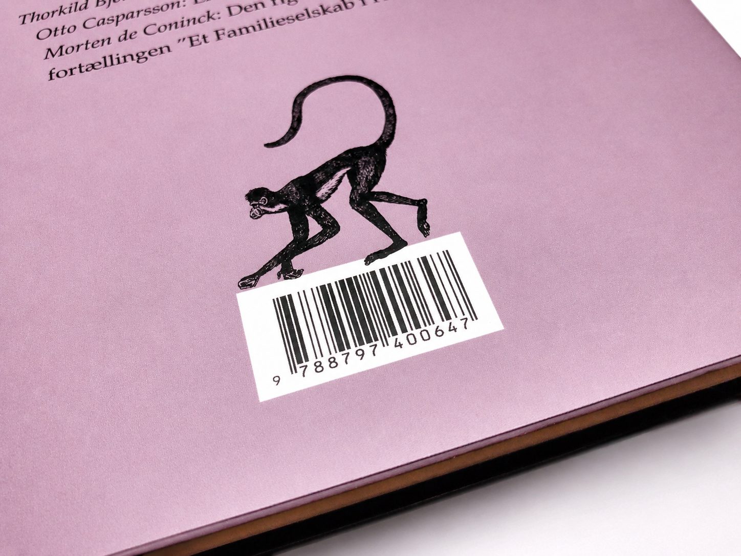 Close-up detail from the back cover of De elskende showing the monkey illustration and barcode