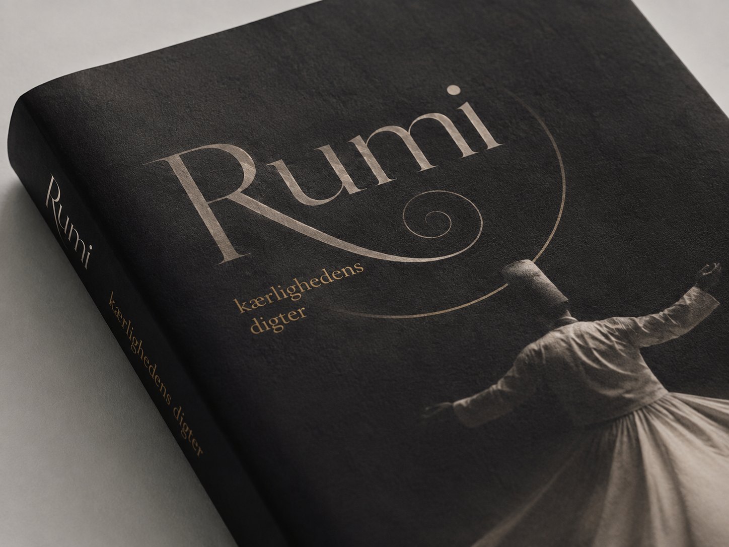 Close-up detail of the Rumi cover with spiral-like title typography and a whirling dervish
